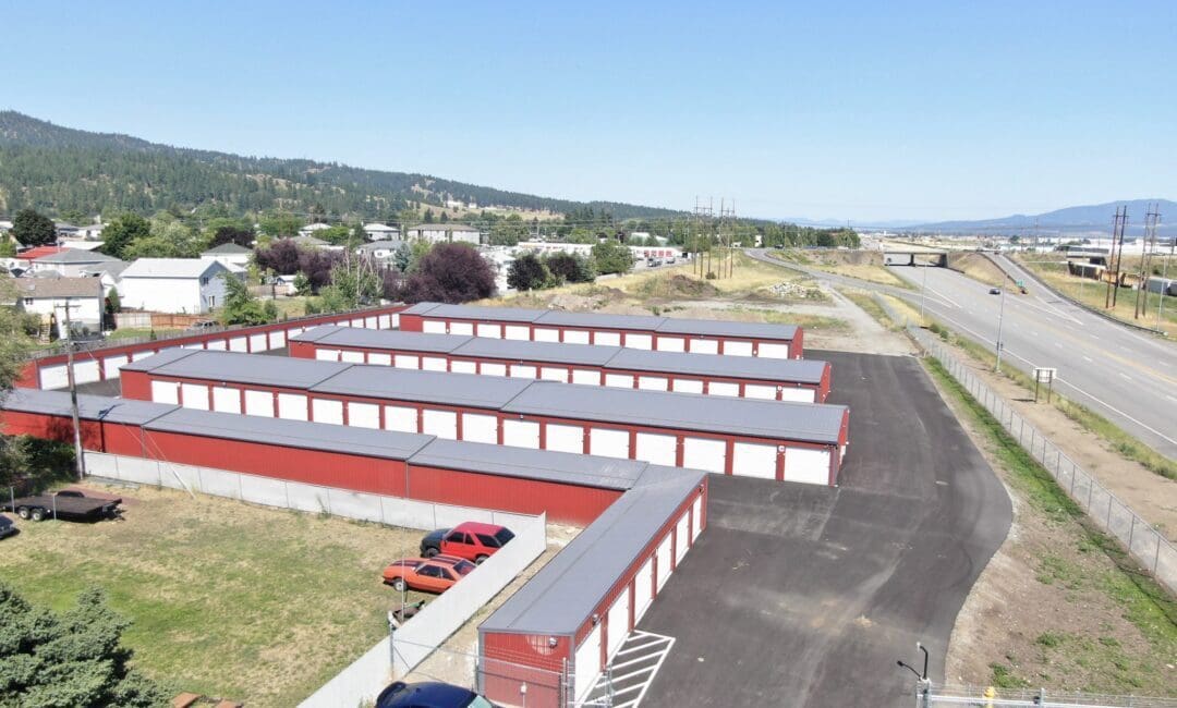 aerial view of a storage facility in Spokane, WA: red siding, grey roof, and white overhead doors