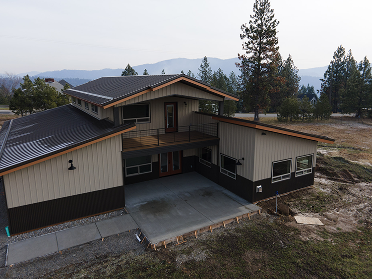 A wrap around barndominium layout design, with the living space in the center, surrounded by the workshop