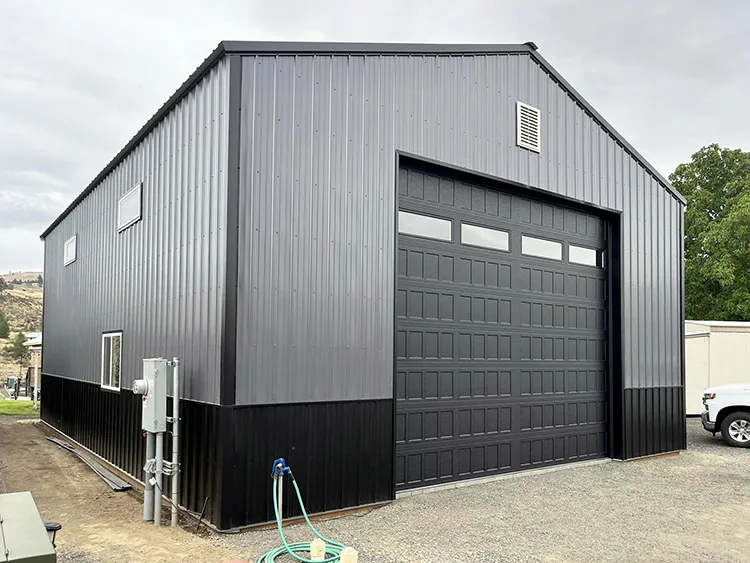 A grey and black detached pole barn garage