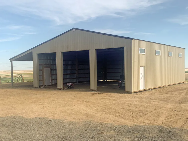 A beige metal building with tall door opening used as a farm equipment storage building