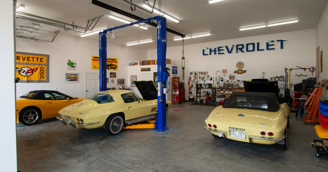 A hobby workshop interior with car lifts and classic cars