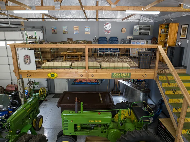 A living area loft above tractor storage in a pole barn garage