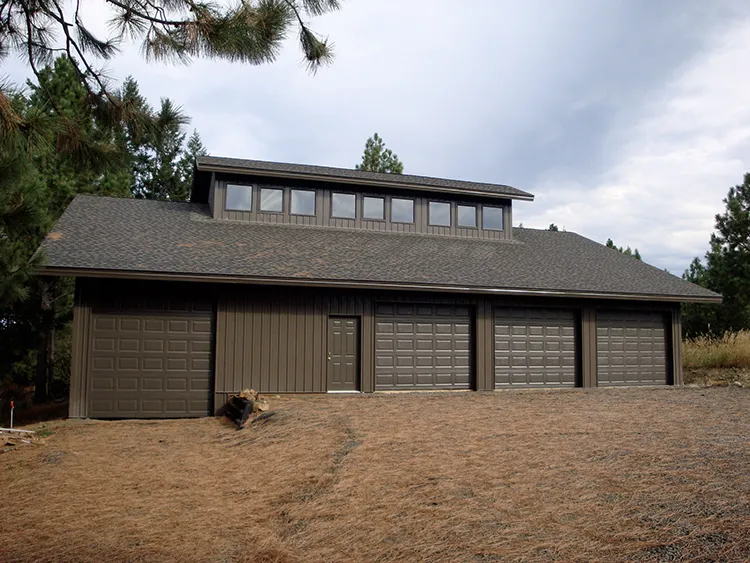 A brown pole barn home that looks much more like a shop vs a traditional home