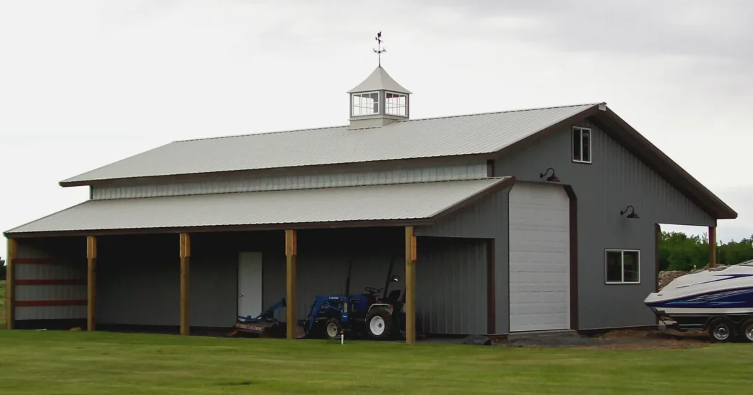 A grey pole barn with ridge cap ventilation