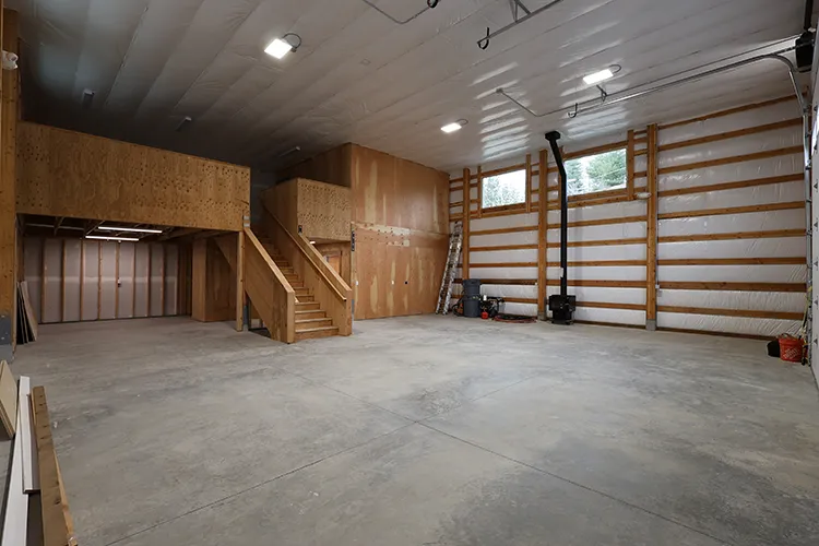 A wooden entry to a large loft in a pole barn garage