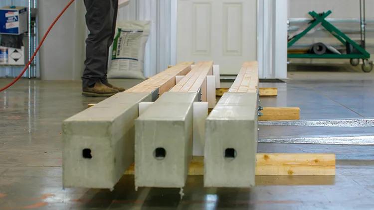 Three precast perma-column post anchors lay on a pallet