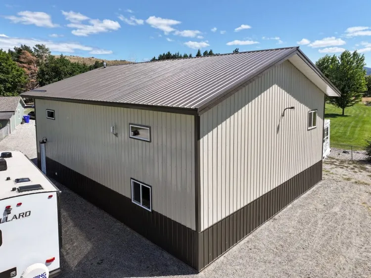 Fixed high-set steel building windows near the roofline on a metal shop exterior