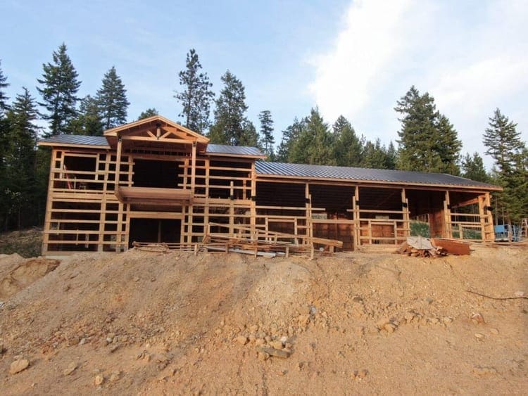 A crew assembling pole barn framing on a post-frame shop, the work a pole barn builder handles on site