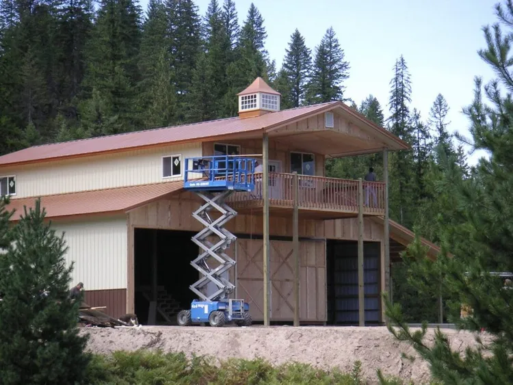 Pole barn framing showing posts and trusses, the structural system the poles for pole barn construction support