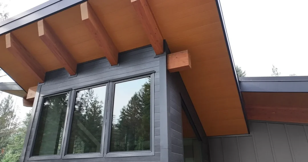 A black barndominium with a wood look roof