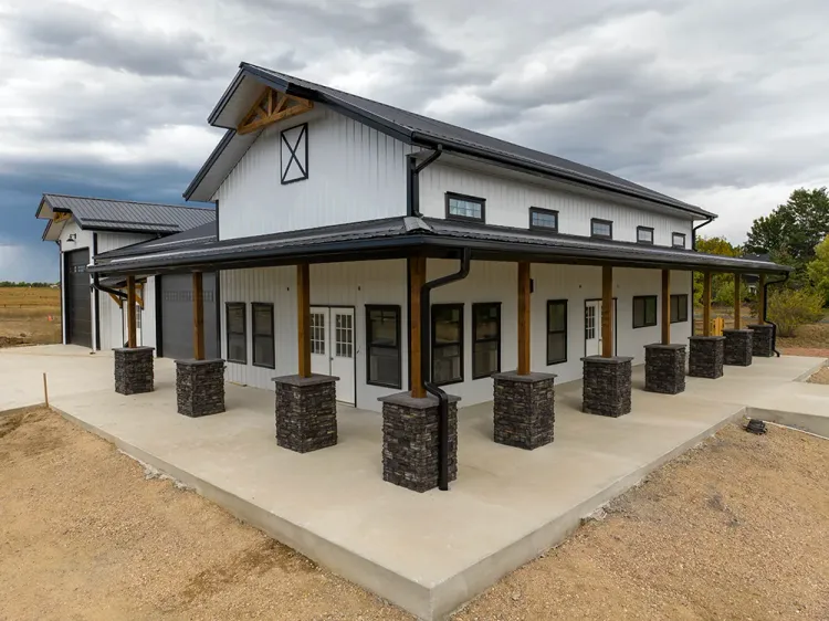 Corner view of a finished custom white barndominium, the kind of home barndominium financing pays for